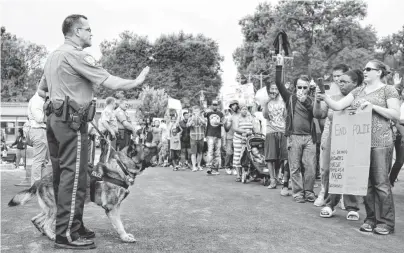  ?? SID HASTINGS, AP ?? Protesters confront police during an impromptu rally Sunday, following the shooting of unarmed Michael Brown, 18, by police in Ferguson, Mo.