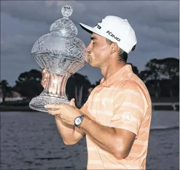  ?? MICHAEL ARES / THE PALM BEACH POST ?? Rickie Fowler kisses the Honda Classic trophy Sunday after winning by four strokes. The Jupiter resident began the final round at PGA National with a four-shot lead.