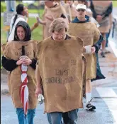  ??  ?? Father John Dear, center, and dozens of other protesters wore burlap sacks as they made the annual peace march in Los Alamos in 2007.