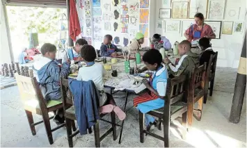  ?? Picture: SUPPLIED ?? ART THAT ROCKS: Artist and teacher Helen Averbuch with children from Ingubo Children’s Haven at the Artship studio. The children enjoyed painting their own rocks at a fun lesson during the Artship exhibition at Calico Academy recently. (Children’s faces blurred to protect their identity).