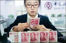  ?? ZHANG YUN / CHINA NEWS SERVICE ?? A bank employee counts cash in Taiyuan, capital of Shanxi province.