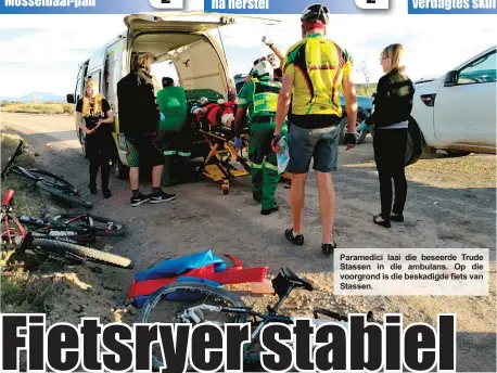  ??  ?? Paramedici laai die beseerde Trude Stassen in die ambulans. Op die voorgrond is die beskadigde fiets van Stassen.