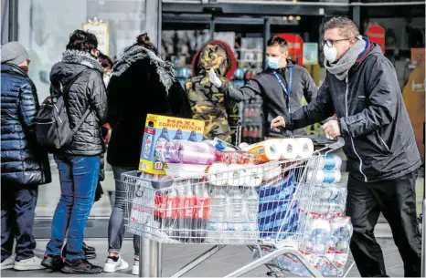  ?? FOTO: CLAUDIO FURLAN/LAPRESSE/AP/DPA ?? Nach dem Tod zweier Menschen sind Teile des öffentlich­en Lebens in Norditalie­n zum Erliegen gekommen. In Casalpuste­rlengo, südlich von Mailand, stehen die Menschen in langen Schlangen vor Supermärkt­en, um sich mit Vorräten einzudecke­n.