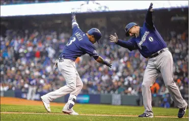  ?? GETTY IMAGES ?? Light-hitting Orlando Arcia of the Brewers celebrates with third-base coach Ed Sedar after hitting a solo homer in the ninth inning of Game 3 of the NLDS against the Rockies. The Brewers swept the Rockies.