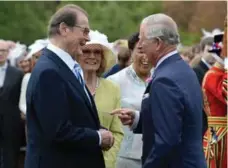  ?? ANTHONY DEVLIN/WPA POOL/GETTY IMAGES FILE PHOTO ?? Prince Charles met with Sir Roger Moore in May 2016. In 2003, Moore was knighted by Queen Elizabeth II, not for film, but for his humanitari­an work.