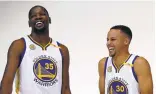  ?? EZRA SHAW/GETTY IMAGES ?? New teammates Kevin Durant, left, and Stephen Curry get a laugh posing for pictures on media day.