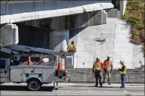  ??  ?? Crews check damage to the 10th Avenue North overpass. The beam that was hit is under a right lane on the overpass that is closed due to constructi­on. There were no injuries in the crash, an official said.