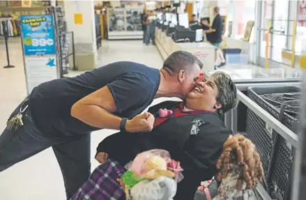  ?? Photos by Joe Amon, The Denver Post ?? Store manager Scott Jeffers kisses Lorraine Espinoza, the store greeter for 10 years at the Arc Thrift Store on West Colfax Avenue in Lakewood.