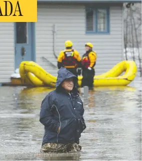  ?? ADRIAN WYLD/THE CANADIAN PRESS ?? Paul Graveline makes his way through flood waters on Friday outside his home in Ottawa, where soldiers have been sent in to help sandbag as river levels rise.