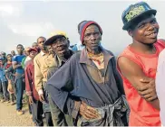  ?? Picture: JEKESAI NJIKIZANA/AFP ?? HELP AT HAND: Villagers queue to receive food handouts in Chimaniman­i, Zimbabwe