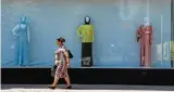  ??  ?? A woman walks past a shop selling Islamic clothes for women on an avenue named after Russian President Vladimir Putin in central Grozny.