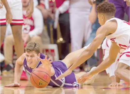  ?? DOUG MCSCHOOLER/AP ?? Northweste­rn forward Miller Kopp dives for a loose ball during the first half Saturday against Indiana.