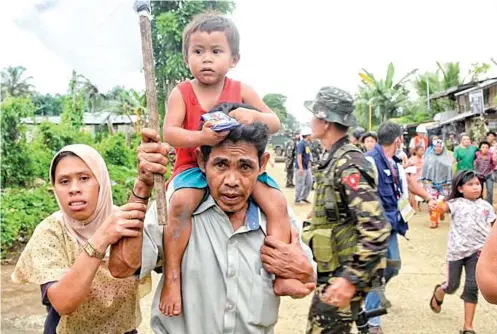  ?? SUNSTAR / ALAN TANGCAWAN ?? EXODUS. Residents of Marawi City continue their exodus as the government’s offensive against members of the Maute group, who laid siege to the capital of Lanao del Sur Tuesday last week, entered its tenth day.