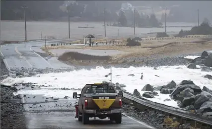  ?? ANDREW VAUGHAN, THE CANADIAN PRESS ?? Water and debris block Highway 207 in Lawrenceto­wn, N.S. A winter storm hit Nova Scotia, New Brunswick, P.E.I. and Newfoundla­nd and Labrador.