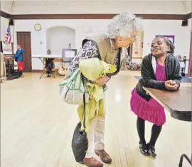  ??  ?? CHARLOTTE ORR, left, greets Maua Shukrani, 8, at Holy Spirit Church in Missoula, Mont. Maua arrived in the U.S. last fall with her parents and four siblings.