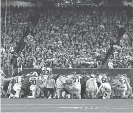  ?? GETTY IMAGES ?? Bills players huddle and pray after teammate Damar Hamlin collapsed on the field after suffering cardiac arrest Monday in Cincinnati.