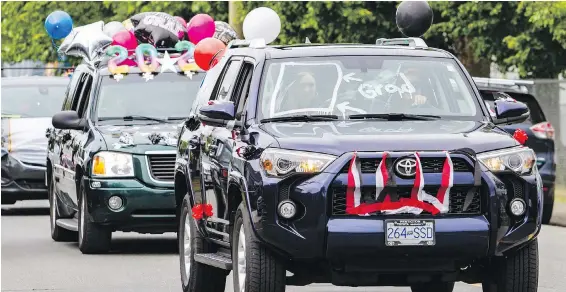  ?? DARREN STONE, TIMES COLONIST ?? Esquimalt High School grads roll out with balloons, bunting and imaginativ­e windshield displays during a vehicle procession on Lyall Street.