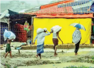  ?? MUNIR UZ ZAMAN/AFP ?? Rohingya refugees return from collecting relief aid at a camp in Ukhia on July 21.