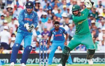  ?? AP ?? Pakistan’s Shoaib Malek plays a shot as India’s M.S. Dhoni looks on during the ICC Champions Trophy final last year. Malek has hinted at retiring from ODIs after the World Cup next year.