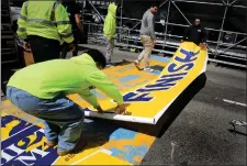  ?? NANCY LANE — BOSTON HERALD ?? Workers lay down the Boston Marathon finish line on Wednesday.