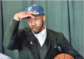  ?? APPEAL ?? Memphis Grizzlies second-round draft pick Jevon Carter adjusts a team cap during Friday's press conference at FedExForum. BRANDON DILL/FOR THE COMMERCIAL