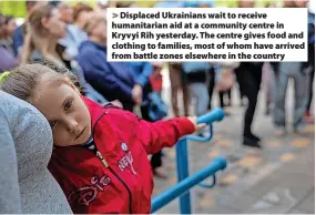  ?? ?? Displaced Ukrainians wait to receive humanitari­an aid at a community centre in Kryvyi Rih yesterday. The centre gives food and clothing to families, most of whom have arrived from battle zones elsewhere in the country