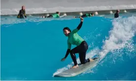  ?? ?? Donna Lu catching a wave at Urbnsurf Melbourne. ‘On land, we stretch and practise our pop-ups … which I promptly forget about as soon as we are in the water.’ Photograph: The Guardian