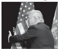  ??  ?? President Donald Trump celebrates his 72nd birthday Thursday by hugging a flag — a daily tradition he instilled the second time he switched from being a Democrat to a Republican in 2012.