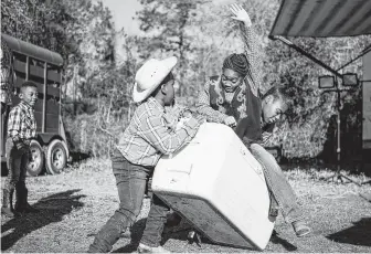  ?? Mark Mulligan / Staff photograph­er ?? Keigen Mack, 5, turns a cooler into a bucking bull as Jada Pierre, 9, tries to hold on before heading out Friday for the last day of their trail ride, which started in Cheek and ended in Memorial Park.