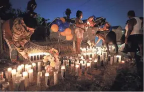  ?? MARIO TAMA/GETTY IMAGES ?? People light candles Tuesday at a makeshift memorial where Dijon Kizzee, 29, was killed by Los Angeles sheriff’s deputies.