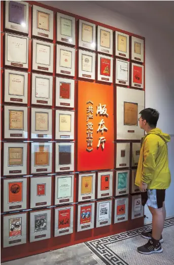  ??  ?? A visitor goes through various versions of The Communist Manifesto on display at the former residence of Chen Wangdao. — All photos by Wang Rongjiang