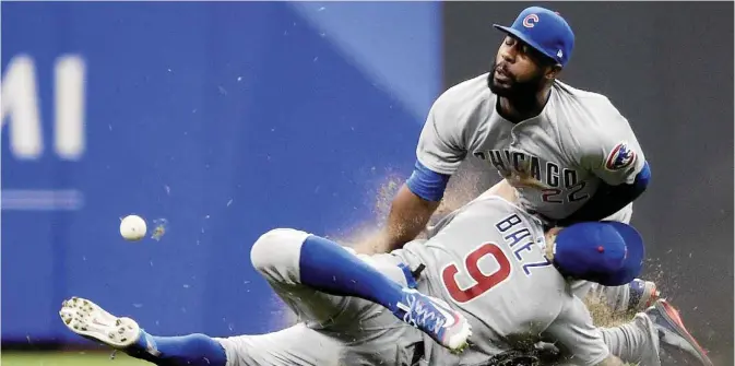  ??  ?? MILWAUKEE: Javier Baez #9 of the Chicago Cubs collides with Jason Heyward #22 while chasing a fly ball during the sixth inning of a game against the Milwaukee Brewers at Miller Park on Friday in Milwaukee, Wisconsin. —AFP