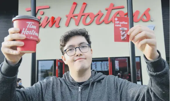  ??  ?? Liam Taniguchi received a year’s free coffee for being first through the door at Tim Hortons in Washington.