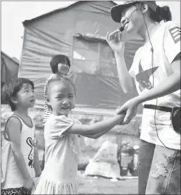  ?? LIU RANYANG / CHINA NEWS SERVICE ?? A teacher plays with children at a makeshift kindergart­en in a relocation site for quake victims in Yiliang, Yunnan province.