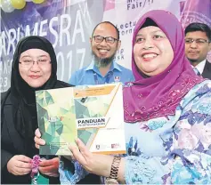  ??  ?? Rubiah (right) holding the PTAR Library Guide book for the launching of PTAR Customer Appreciati­on Day here yesterday as other guests look on. — Photos by Chimon Upon.