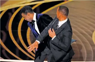  ?? AP PHOTO/CHRIS PIZZELLO ?? Will Smith, right, hits presenter Chris Rock on stage while presenting the award for best documentar­y feature at the Oscars on March 27 at the Dolby Theatre in Los Angeles.