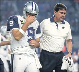  ??  ?? The Cowboys’ Tony Romo is led to the sidelines against the Panthers.