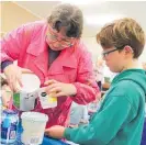  ??  ?? Horowhenua Art Society’s Vicky Millman stocks up Connor Williams, 8, with more paint.
