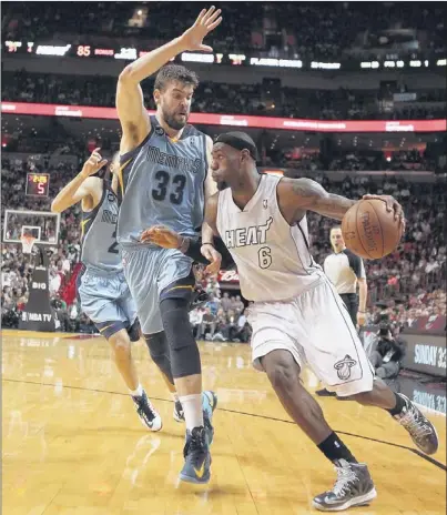  ?? DAVID SANTIAGO/ASSOCIATED PRESS ?? LeBron James, who scored Miami’s last eight points, drives against Grizzlies center Marc Gasol during the fourth quarter in Miami on Friday.