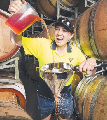  ??  ?? LOOKING SHARP: Whitney Schoenfisc­h, manager of manufactur­ing at Australian Vinegar, pours a drop of strawberry vinegar.