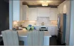  ??  ?? The kitchen offers tile backsplash­es, a circular light fixture and stainless-steel appliances.