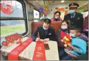  ?? TANG ZHENJIANG / FOR CHINA DAILY ?? Above: A crew member on the train writes couplets for passengers as gifts for Lunar New Year.