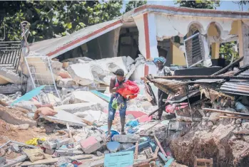  ?? JOSEPH ODELYN/AP ?? Locals salvage what they can from their homes Sunday in Haiti, which was rocked by a quake Saturday.