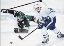  ?? HANNAH FOSLIEN
THE ASSOCIATED PRESS ?? Minnesota’s Ryan Suter, left, watches as Leafs’ Zach Hyman takes the puck in the third period Saturday, depositing it in the empty net..