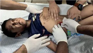  ?? Reuters file ?? A Palestinia­n boy, who was wounded during a protest at the Israel-Gaza border, is treated at a hospital in the southern Gaza Strip. —