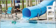  ?? Lynn Atkins/The Weekly Vista ?? During a few minutes of free time at the end of swim team practice, the young swimmers take on the slide at Kingsdale.