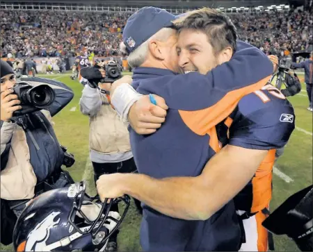  ??  ?? By Jack Dempsey, AP
Mile high indeed: Broncos quarterbac­k Tim Tebow hugs coach John Fox on Sunday after their 29-23 overtime win vs. the Steelers in a wild-card game.