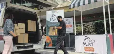  ??  ?? Groceries ordered ahead from All Day Supermarke­t are loaded onto customer’s vehicle at Vista Mall Daang Hari’s designated DROPBUY station