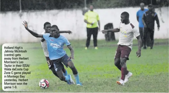  ??  ?? Holland High’s Jahnoy Mcintosh (centre) gets away from Herbert Morrison’s Leo Taylor in their ISSA/ Wata dacosta Cup Zone C game played in Montego Bay yesterday. Herbert Morrison won the game 1-0.