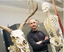  ?? JEAN LEVAC ?? Scott Rufolo stands between a human skeleton reproducti­on and a deer skeleton. The expert says bone knowledge helps volunteer search and rescuers make decisions when searching for human bodies.